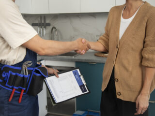male-plumber-working-with-client-fix-kitchen-problems
