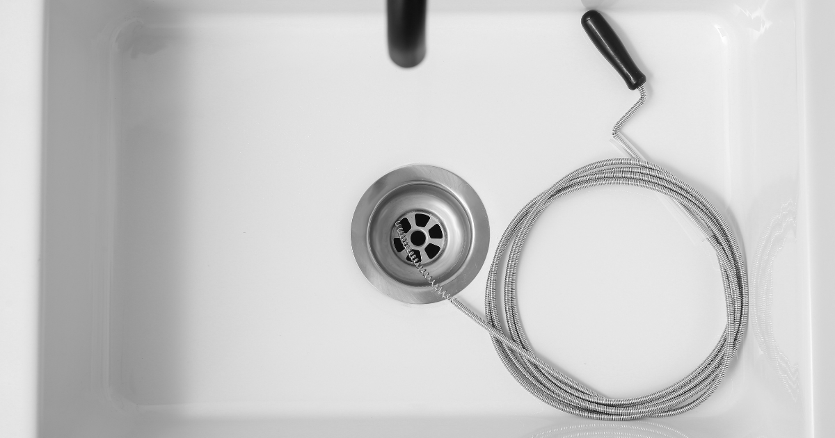 Plumber's hand opening a trap fixing for a clogged drain repair service Plumber's hand opening a trap fixing for a clogged drain repair service